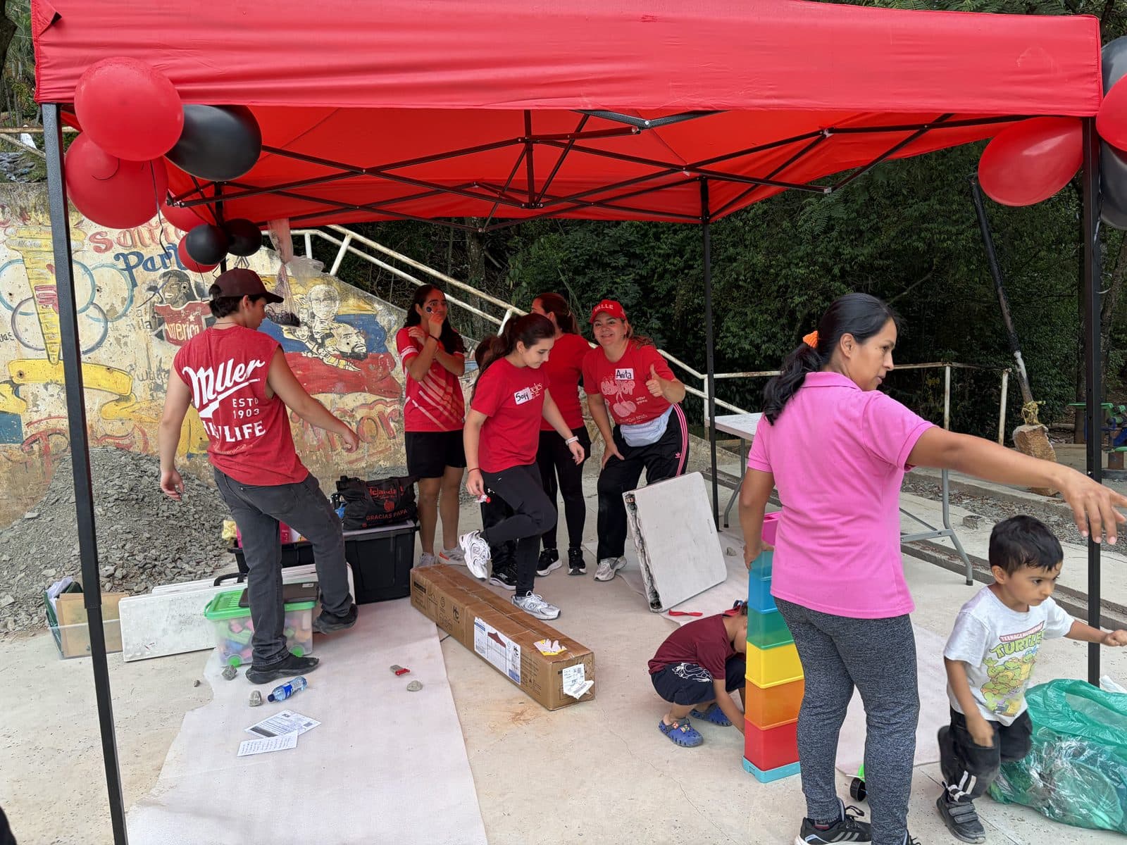 El equipo arma la carpa roja y organiza el espacio antes de que lleguen los niños