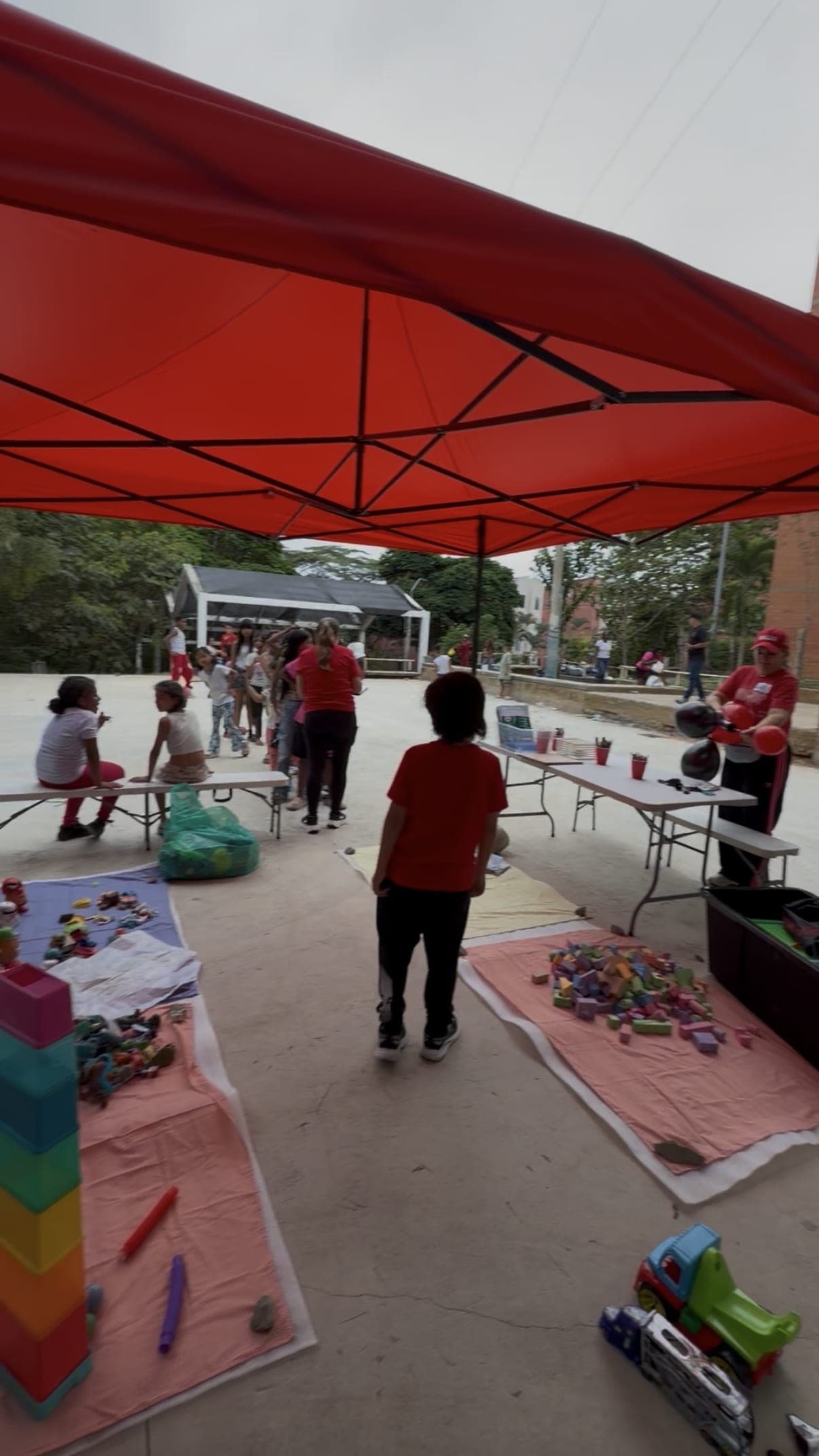Vista bajo la carpa con los niños jugando sobre las mantas durante la sesión