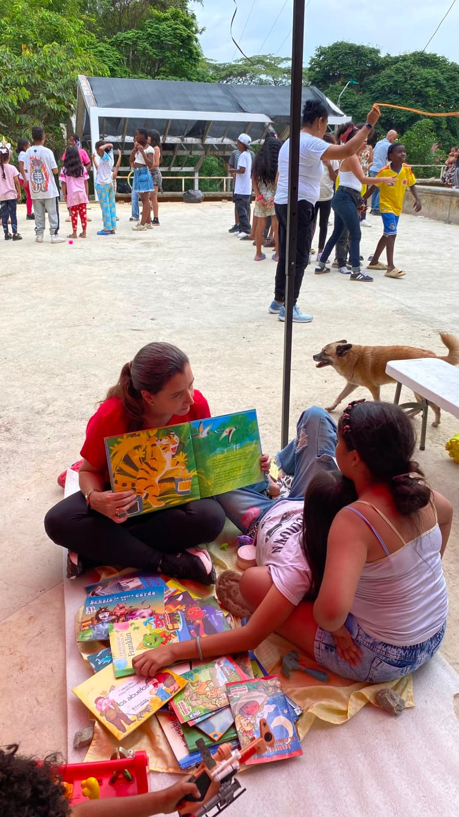 Dos niñas leen cuentos infantiles sentadas en el suelo junto a la colección de libros